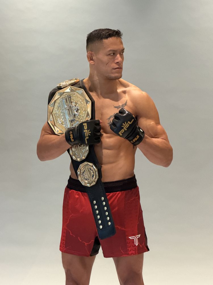 Costello holding the PFL belt in red shorts